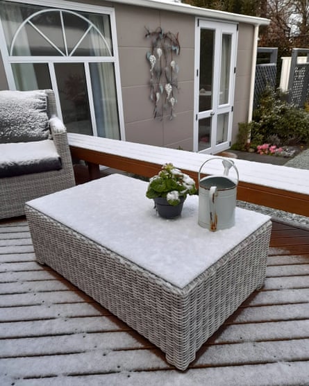 Snow covers outdoor furniture and deck