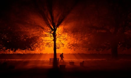 A man uses a torch to walk through a park during cold fog at night in Athboy, Ireland, 31 October.