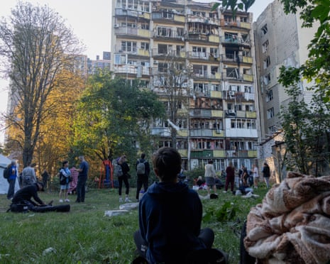 A boy looks at a damaged residential building following a Russian strike in Kyiv.