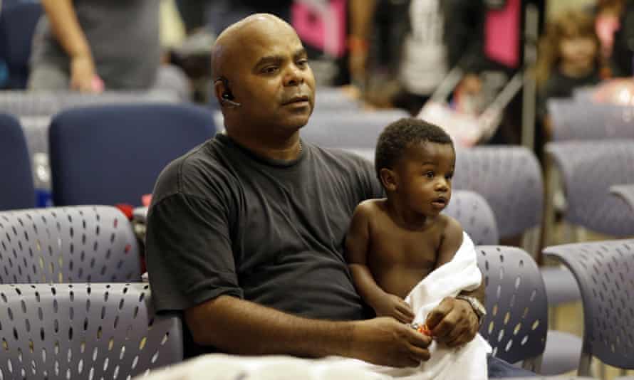 Will Sutton, an evacuee, holds his 11-month son Jayden at the Lakewood Church in Houston.