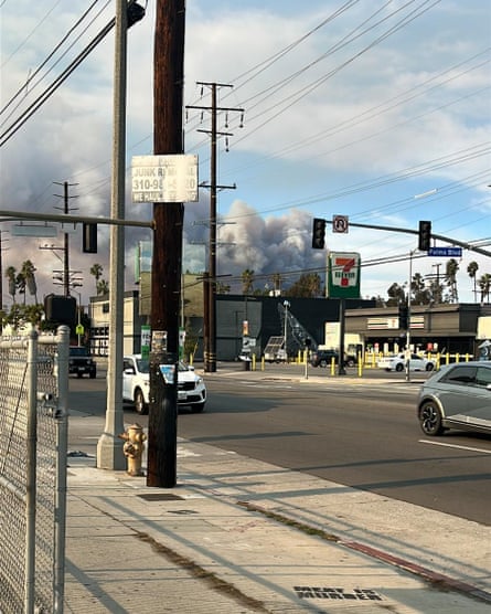 Smoke rises over a street with cars