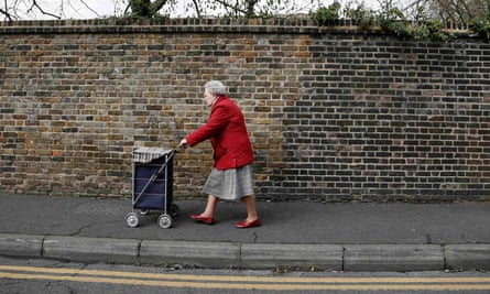 Elderly woman pushes trolley down street