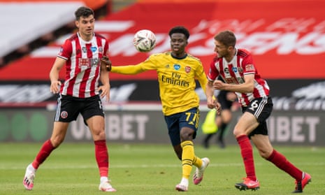 Arsenal’s Bukayo Saka (centre) tries to get the better of two Sheffield United players.