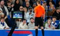 Referee Michael Salisbury checks the VAR monitor at a Chelsea v Brighton & Hove Albion Premier League match on 15 May before showing Reece James the red card