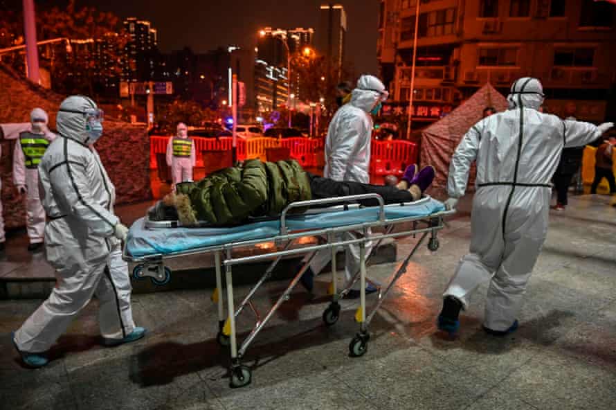 Medics arrive with a patient at Wuhan Red Cross hospital, 25 January