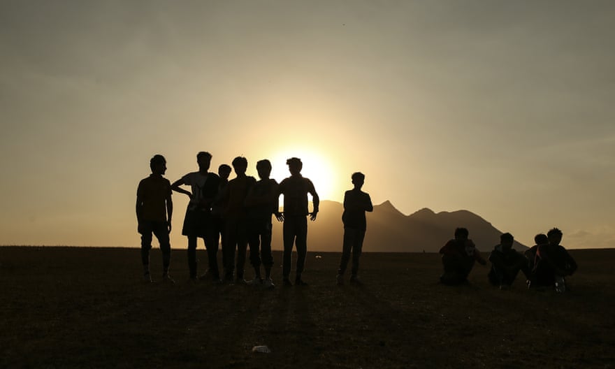 Young men in silhouette on horizon