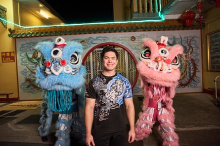 Kelvin Tran, co-founder and team leader of Qing Fong Dragon and Lion Dance team, flanked by a blue and pink lion
