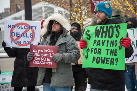 Protesters hold signs opposing a datacenter power deal
