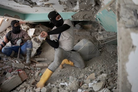 Volunteers using hammers in search operations in the rubble of OPPE 25