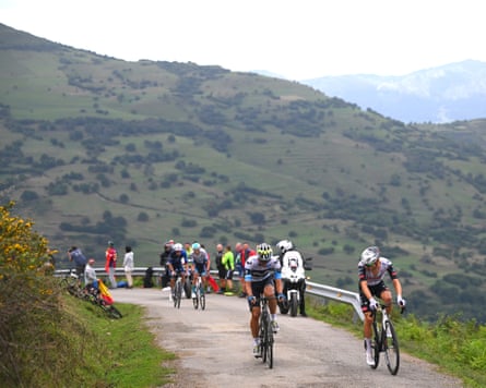 Javier Romo and Juan Ayuso cycling against a hilly backdrop