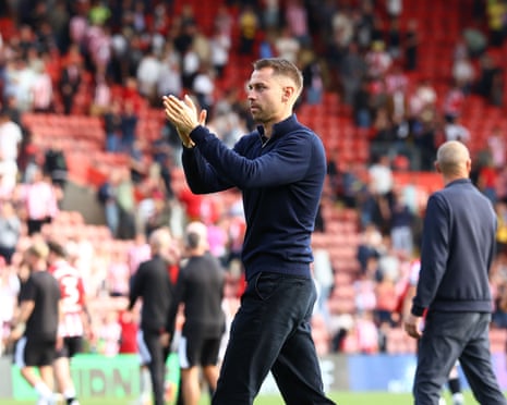 Southampton head coach Tonda Eckert claps his hands on the pitch, with a stadium crowd behind him