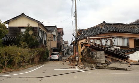 Badly damaged buildings along a street in the city of Wajima