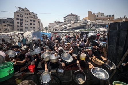 Crowds of people holding out bowls