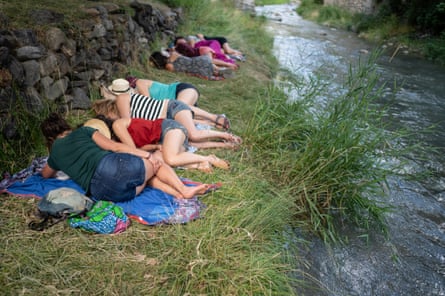 Eine Gruppe von Menschen macht ein Nickerchen am Fluss