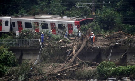 An emergency crew works on a train derailed due to landslides caused by heavy rain in Karatsu city, Saga prefecture.