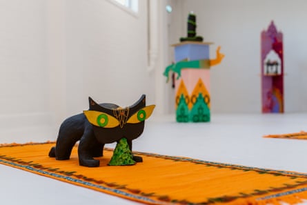 A sculpture of a vomiting animal with wide eyes stood on a yoga mat.