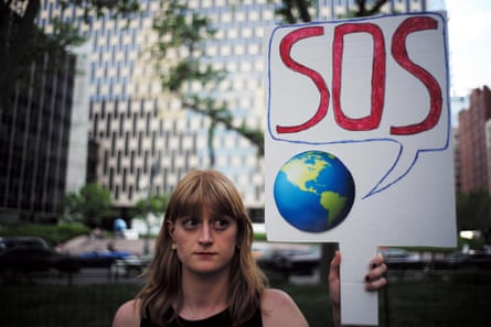 A woman displays a placard during a demonstration in New York on June 1, 2017, to protest US President Donald Trump’s decision to pull out of the 195-nation Paris climate accord deal. US President Donald Trump earlier announced America is “getting out” of a deal he said imposed “draconian” burdens that would cost the US millions of jobs and billions in cold hard cash. / AFP PHOTO / Jewel SAMADJEWEL SAMAD/AFP/Getty Images