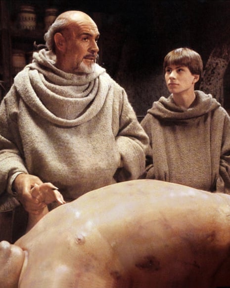 Sean Connery and Christian Slater, as monks, examine a swollen corpse