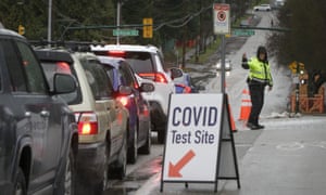 A police officer directs the traffic outside a Covid-19 test site in Vancouver, British Columbia, Canada, on 18 December as cases continue to soar across Canada.