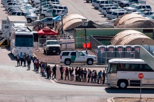 Migrants board buses to take them to shelters after their release.