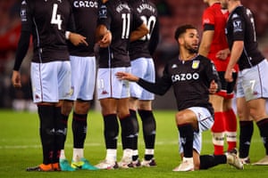 Aston Villa’s Douglas Luiz kneels behind the defensive wall to defend a free kick.