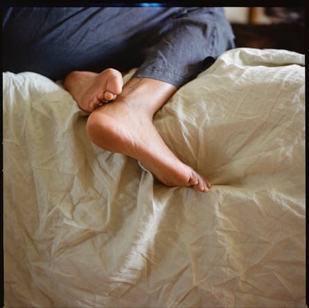 Poppy Noor’s legs as she sits on a couch in her home