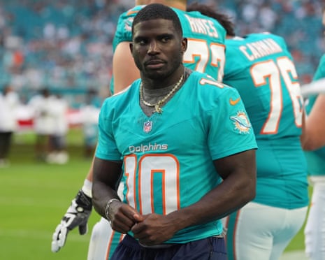 Tyreek Hill stands on the sidelines in a teal Dolphins jersey before a game