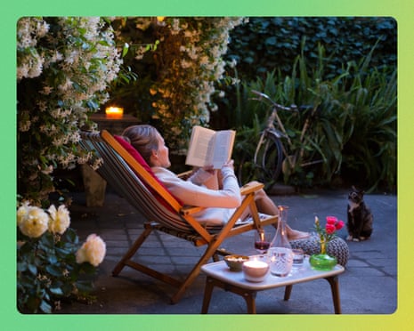 A woman reclines in a striped deck chair reading a book, a cat nearby, in a candlelit garden