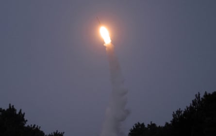 Missile flying through the sky at night.