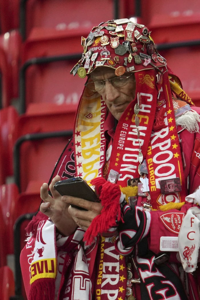 A Liverpool fan checks his mobile phone prior to kick-off of the Premier League match between Liverpool and Newcastle United at Anfield.
