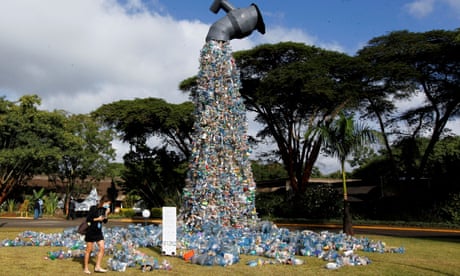 A delegate in Kenya looks at a 30-ft art installation urging people to ‘turn off the plastic tap’