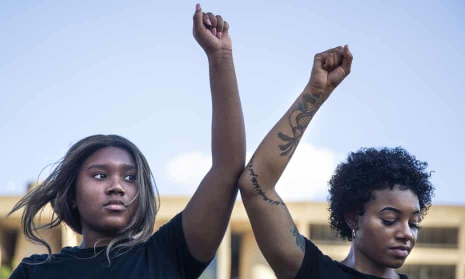 Tyra Wilson and Kita Williams participate in an 8-minute and 46-second kneel in honor of George Floyd during a demonstration at Dallas City Hall on 4 June.