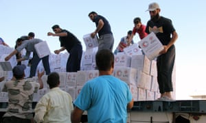 Syrians unload boxes after a 48-truck convoy from the ICRC, SARC and UN entered the Syrian rebel-held town of Talbiseh.