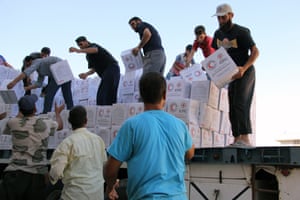 Syrians unload boxes after a 48-truck aid convoy entered the rebel-held town of Talbiseh, a besieged area in northern rural Homs, in July.