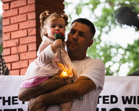 A man holds a young girl.