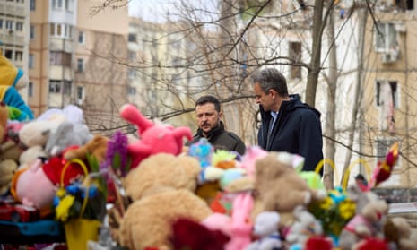 Ukrainian President Volodymyr Zelensky (L) and Greek prime minister Kyriakos Mitsotakis stand in front of children toys placed by people at the site of a deadly Russian drone attack in Odesa this week.