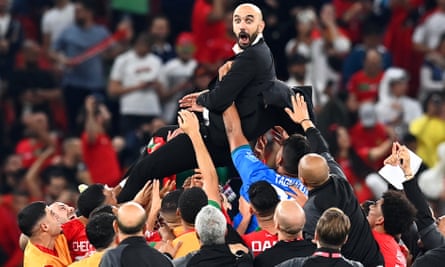 Morocco's players and staff give head coach Walid Regragui a lift after their win over Portugal saw them become the first African nation to reach a World Cup semi-final.