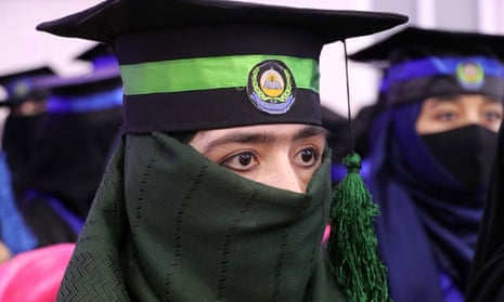 Afghan woman wearing veil and mortarboard at graduation ceremony.