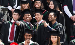 Overseas students in traditional gowns and mortar boards take a selfie on graduation day at Aberystwyth University