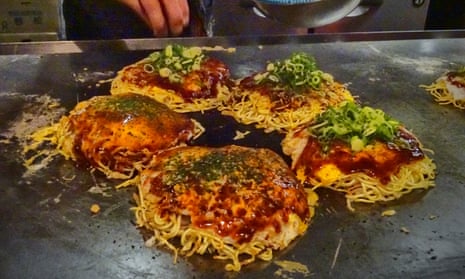 Okonomiyaki get their final garnish at a restaurant near Hiroshima, Japan.