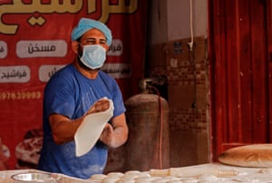 A Palestinian baker wearing a protective mask prepares the dough for fresh bread at a bakery in Gaza City during lockdown in the Palestinian enclave due to increasing cases of coronavirus infections.