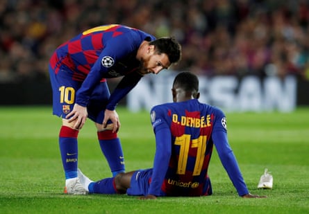 Lionel Messi checks on an injured Ousmane Dembélé.