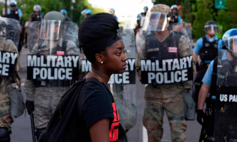A demonstrator in front of a row of military police outside the White House on 1 June.
