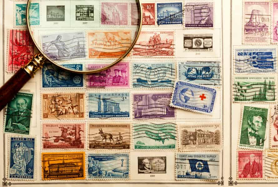 Collection of old stamps shown with magnifying glass