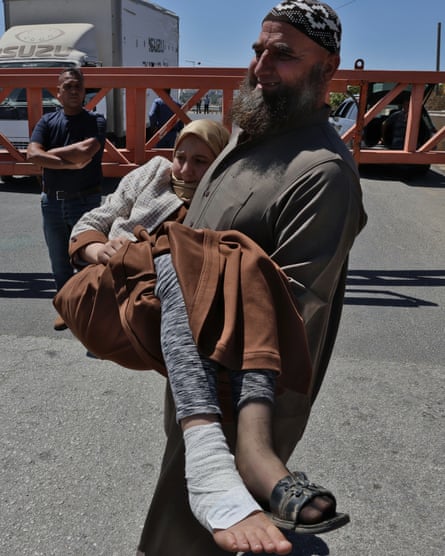 Haytham Adnan Murad carrying his daughter Balqis around an Israeli roadblock.