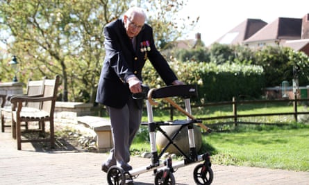 Captain Tom with his walking frame. He is wearing a jacket and medals