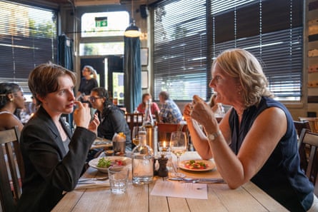 Margaret and Clare clink chat across a restaurant table
