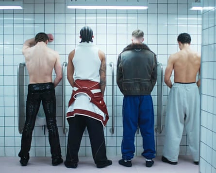 A group of people standing at a urinal