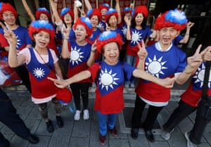 People smiling joyfully, wearing wigs and t-shirts with the Taiwanese flag