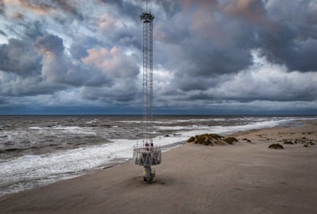 Sunset over an artificial beach as the waves lap the sand